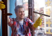 Homem limpando vidro ilustrando o artigo sobre como limpar vidros.